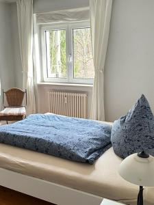 een bed met een blauw dekbed en een raam bij Stadt- Naturnah, Traumblick und Balkon in Baden-Baden +55 foto's