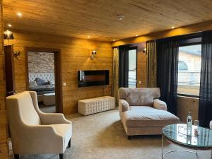 a living room with a couch and chairs and a tv at Wolfstein - Le Boutique Hotel in Bad Harzburg