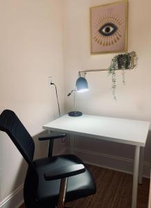 einen Schreibtisch mit einem Stuhl und einen Schreibtisch mit einer Lampe in der Unterkunft Comfortable Apt #4 with Office Space in Halifax