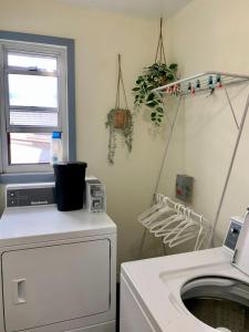 a laundry room with a washing machine and a window at Comfortable Apt #4 with Office Space in Halifax