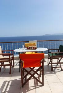 a table and chairs on a balcony with the ocean at Mirabello Sea House in Agios Nikolaos