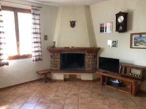 un soggiorno con camino e TV di Casa Natalina a Casal Fiumanese