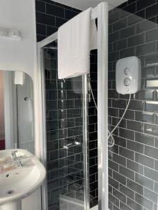 La salle de bains est pourvue d'une douche et d'un lavabo. dans l'établissement Mocha Newcastle, à Galway