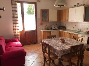 una cucina con tavolo e divano rosso di Casa Natalina a Casal Fiumanese