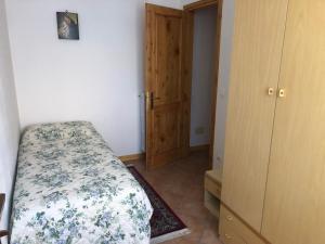 una piccola camera da letto con un letto e un armadio di Casa Natalina a Casal Fiumanese