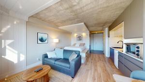 a room with a bed and a couch and a table at Hébergement Mont-Ste-Anne Condos in Beaupré