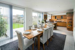 a kitchen and dining room with a table and chairs at Contemporary 5 Bedroom with Garden North Finchley in London