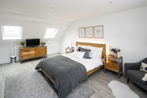 a bedroom with a bed and a tv and a couch at Contemporary 5 Bedroom with Garden North Finchley in London