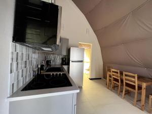 Una cocina con fregadero y refrigerador en una tienda de campaña. en Dome Sweet Dome, en Lampasas 27 fotos más