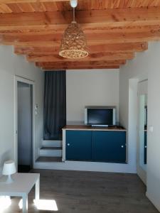sala de estar con armario azul y TV en Gîte Ludomi, en Vercheny