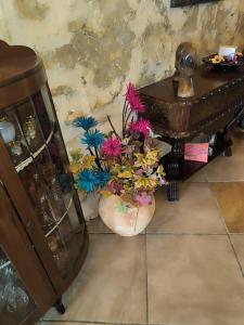 un vase avec des fleurs à côté d'une table dans l'établissement Il figolla b&b, à Ix-Xagħra