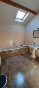 een grote badkamer met een bad en een wastafel bij B&B Euverbraeke in Beveren