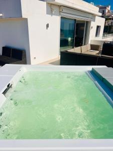a bath tub filled with green water on top of a house at V Penthouse in Vieste