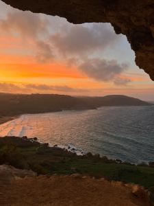 a view of the ocean at sunset from a cave at Il figolla farmhouse in Xagħra