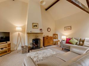 a living room with a couch and a fireplace at 1 Bed in Crewkerne 91795 in West Chinnock