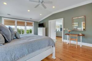 ein Schlafzimmer mit einem Bett, einem Tisch und einem Spiegel in der Unterkunft Luxury Beach Front Home: Breath Taking Views in Tybee Island