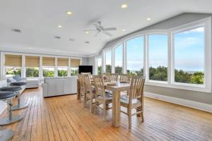 ein Esszimmer mit Tisch und Stühlen und Fenstern in der Unterkunft Luxury Beach Front Home: Breath Taking Views in Tybee Island