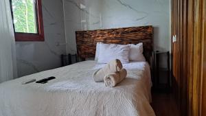 HOTEL, VILLAS y GLAMPINGS MYA -PUERTO VIEJO, Limon, CR في بويرتو فيجو: غرفة نوم عليها سرير وفوط