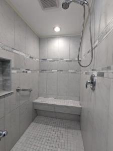 uma casa de banho branca com um chuveiro e uma banheira em Los Gatos Garden Inn Hotel em Los Gatos