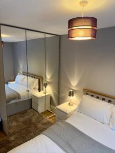 a bedroom with two beds and a mirror at Balcony Breeze - Reading City Centre in Reading