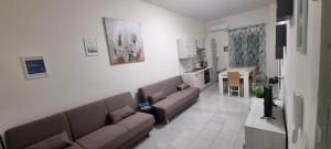 sala de estar con 2 sofás marrones y cocina en Appartamento centro Niscemi 2, en Niscemi