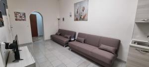 una sala de espera con 2 sofás y TV en Appartamento centro Niscemi 2, en Niscemi
