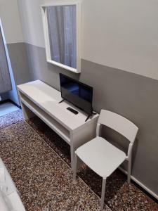 a white desk with a computer and a chair at Guesthouse La Briosa Nicole in Genova