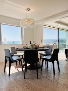 a dining room with a table and chairs and a chandelier at V Penthouse in Vieste