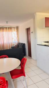 a living room with a table and red chairs at Apartamento com vista para o mar in Conde