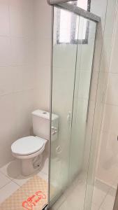 a bathroom with a toilet and a glass shower at Apartamento com vista para o mar in Conde