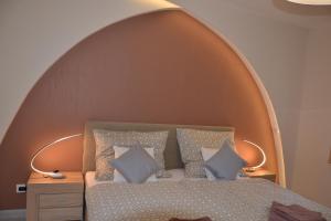 Souvenir Apartmanok في إغير: غرفة نوم بسرير كبير وقوس فوقها