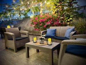 リオ・アトにあるBeach villa with cozy terraceの籐の椅子とテーブル、花が飾られたパティオ