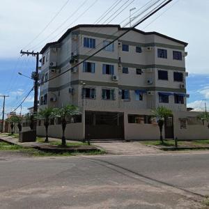 a large white building with palm trees in front of it at TV Conego Leitão 2709 ap 203 in Castanhal