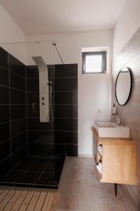 a bathroom with a shower and a sink and a mirror at Zenstay ApartHotel in Topliţa