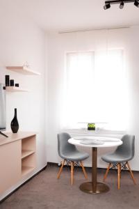 a dining room with a table and two chairs at Zenstay ApartHotel in Topliţa