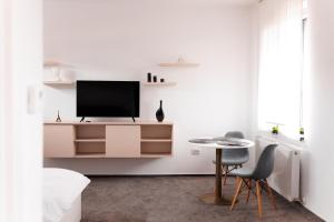 a living room with a tv and a table at Zenstay ApartHotel in Topliţa