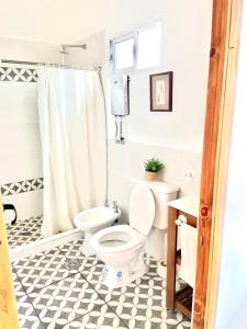 a bathroom with a white toilet and a black and white tile floor at LOFT JUJUY, Alto Gorritti - Departamento cerca del Centro in San Salvador de Jujuy