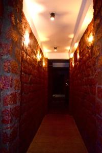 un couloir sombre avec un mur en briques et des lumières dans l'établissement City Hostel Colombo Airport, à Katunayake