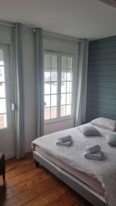 um quarto com 2 camas e 2 janelas em Le Hublot charmante maison au calme Fécamp vue sur le port em Fécamp