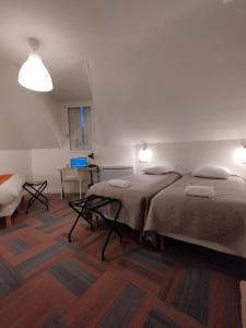 1 dormitorio con 2 camas, mesa y silla en The Originals Access, Hotel Le Canter Saumur en Saumur