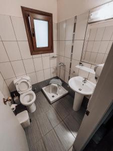 a bathroom with a toilet and a sink at Hotel Eleni in Skopelos Town