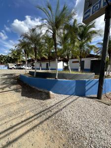 un banc bleu sur une plage de palmiers dans l'établissement Wide Mouth Frog Conchal, à Brasilito