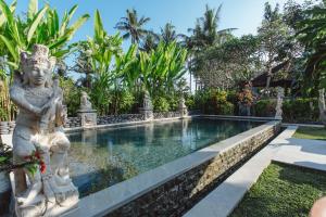 a pool in a garden with a statue next to it at Kishi-Kishi ArtVilla for big company in Saba