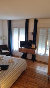 um quarto com 2 camas, uma secretária e janelas em Le Hublot charmante maison au calme Fécamp vue sur le port em Fécamp