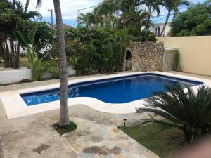 einen Pool mit einer Palme neben einem Haus in der Unterkunft Quiet Charming Apartment #4 in Sosúa