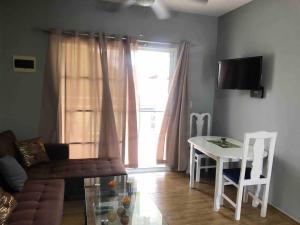 ein Wohnzimmer mit einem Sofa, einem Tisch und einem Fenster in der Unterkunft Quiet Charming Apartment #4 in Sosúa