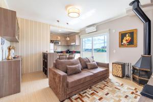 a living room with a couch and a kitchen at Apartamento Pedras Altas in Canela