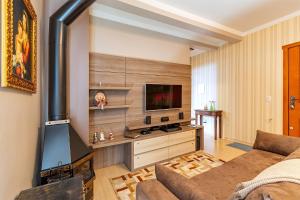a living room with a couch and a flat screen tv at Apartamento Pedras Altas in Canela