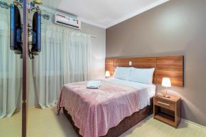 a hotel room with a bed with a pink blanket at Apartamento Pedras Altas in Canela