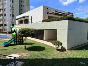 een speeltuin voor een gebouw met een glijbaan bij Hermoso Apartamento moderno y vacacional in Ricaurte